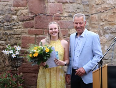 Sarah Herkelrath mit Blumenstrauß und Bürgermeister Klaus Wagner