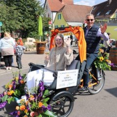 Weingräfin Sarah I. mit Bürgermeister K. Wagner auf der blumengeschmückten Fahrrad-Rikscha